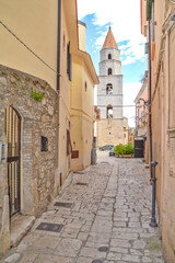 A narrow street among the old houses of Venosa, a medieval village in the Basilicata region, Italy.