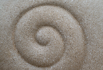 Fototapeta na wymiar Abstract backgrounds of spiral design by hand on the white sand beach.