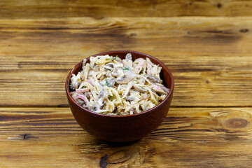 Tasty salad of grated celery root, mushrooms, onions on wooden table