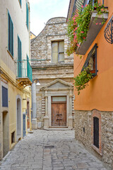 Fototapeta na wymiar A narrow street among the old houses of Venosa, a medieval village in the Basilicata region, Italy.
