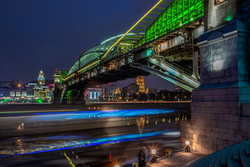 Fototapeta premium View of the colorful Bogdan Khmelnitsky bridge illuminated at night reflecting in the Moskova river at night