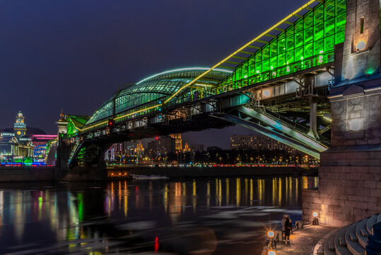 View of the colorful Bogdan Khmelnitsky bridge illuminated at night reflecting in the Moskova river at night