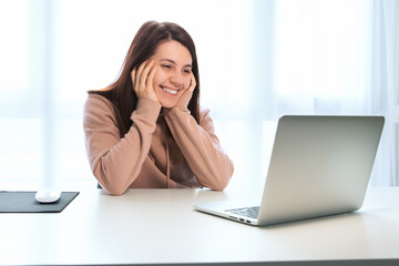 young woman talking by video chat on laptop