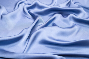 Blue silk or satin luxury fabric texture. Top view.