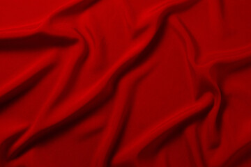 Red silk or satin luxury fabric texture can use as abstract background. Top view.