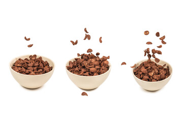 Fototapeta na wymiar Chocolate corn flakes falling to the white bowl isolated on white. Motion.