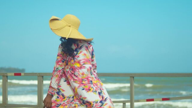 A young woman turns in her beach throw over revealing a bikini bottom