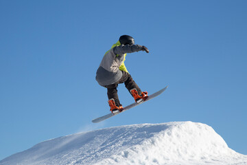 Naklejka na ściany i meble A snowboarder on a snowboard. Extreme winter sports.Rest in winter.