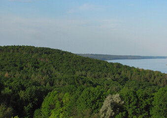 landscape background: green forest, river with islands and blue sky