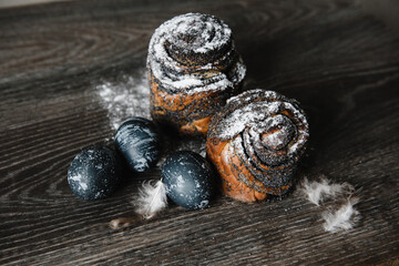easter cake with poppy seeds and blue painted eggs on a wooden table