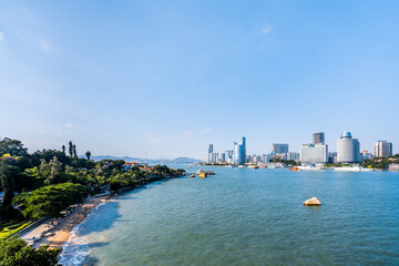 Sunny scenery of Gulangyu Island and city coastline in Xiamen, Fujian, China © Govan