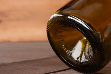 Concave bottom of brown wine bottle on light brown background
