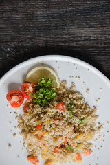 a plate with kenoa salad and vegetables on the background of a wooden table top