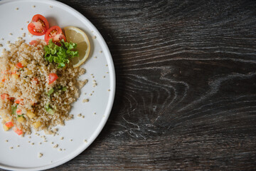 a plate with kenoa salad and vegetables on the background of a wooden table top