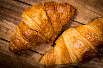 Freshly baked French croissants on a wooden table - studio photography