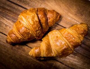 Freshly baked French croissants on a wooden table - studio photography