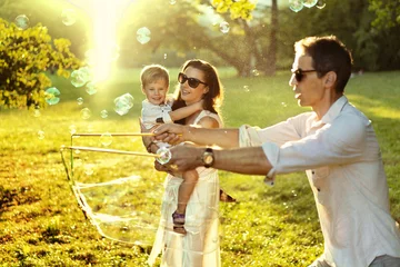 Foto op Canvas Cheerful parents enjoying summer weather with a son © konradbak