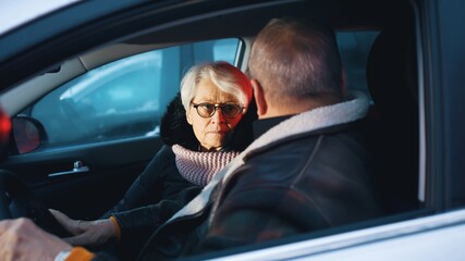 Elderly couple in the car confused with flashing police lights. Speeding ticket. High quality photo