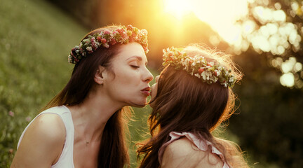 Portrait of a mother kissing her beloved daughter - outdoor concept