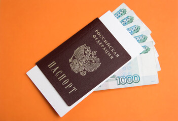 Russian passport with 1000 rubles money on an orange background with a place for the text. Inscription in Russian: Passport, Russian Federation, 1000 rubles.