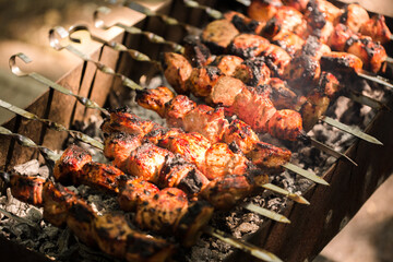 Marinated shashlik preparing on a barbecue grill over charcoal. Shashlik or Shish kebab popular in Eastern Europe. Shashlyk (skewered meat) was originally made of lamb. Roast Beef Kebabs On BBQ Grill.