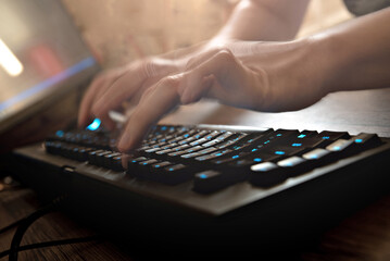 Man's hands are typing on the keyboard at home. Remote work of a programmer close up.