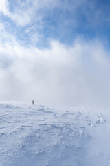 Man on a snowy mountain under the clouds