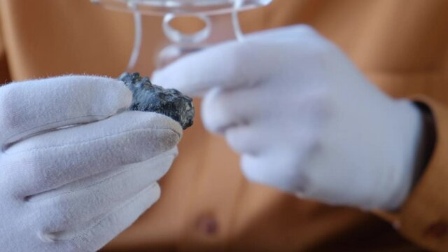 Scientist examines a stone or soil sample of non-earth origin