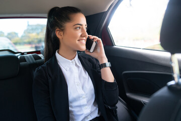 Businesswoman talking on phone in car.