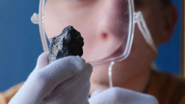 Geologist examines a rock sample with a magnifying glass