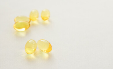 Yellow pills of fish oil on a white background