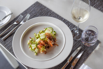 Prawn shrimps salad. Elegant restaurant table top view, white wine and seafood salad. Delicious food dish, appetizer plate closeup. Gourmet meal