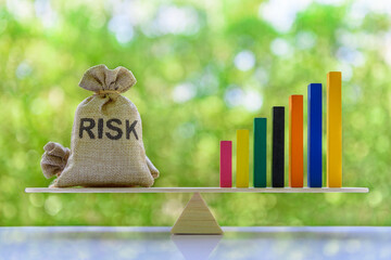 Financial leverage and risk management concept : Rising bar graph and risk bags on a basic balance...