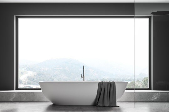 Grey bathroom interior with bathtub on concrete floor
