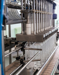 Filling of mineral water in plastic bottles. Water production line.