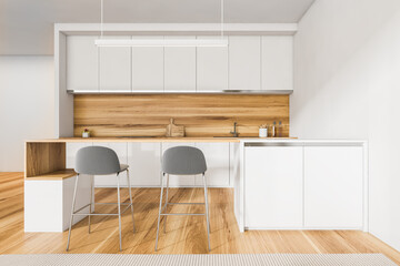 White and wooden kitchen interior with table and chairs, parquet floor