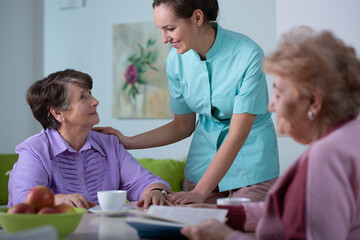 Obraz premium Senior patient of professional nursing home and helpful young nurse