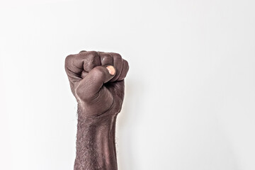 Male hand clenched into a fist on a white background. A symbol of the struggle for the rights of blacks in America. Protest against racism. 