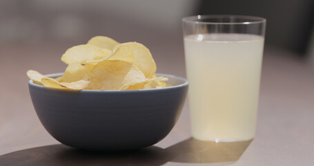 potato chips in blue bowl with ginger beer on background