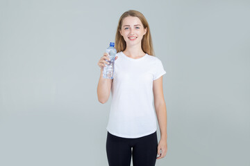 Young woman with a plastic bottle of water. Drink purified water.