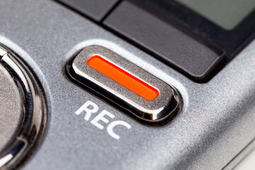 Red REC recording button on a modern pocket audio voice recorder, switch object macro extreme closeup Secretly recording, journalist or reporter equipment, simple live music recording abstract concept - obrazy, fototapety, plakaty