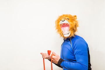 Man in a lion mask playing sport with an elastic band