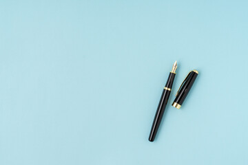 A pen on blue background with a copy space. Flat lay.