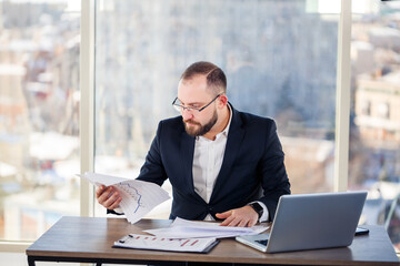 Adult successful male businessman, teacher, mentor is working on a new project. Sits at the table...