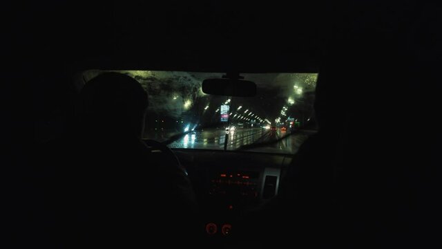 the car drives through the night city in the rain