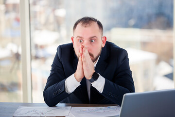 Adult male businessman, teacher, mentor is working on a new project in the office and is nervous....