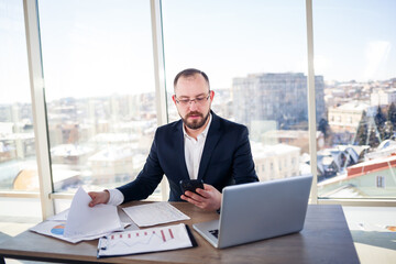 Adult successful male businessman, teacher, mentor is working on a new project. Sits at the table...