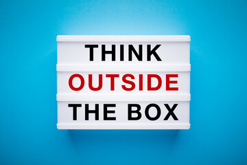 Lightbox on a light blue background with slogan on it: think outside the box.