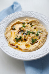 Top view of a plate of healthy homemade creamy hummus on a gray background zucchini and fresh bread for lunch