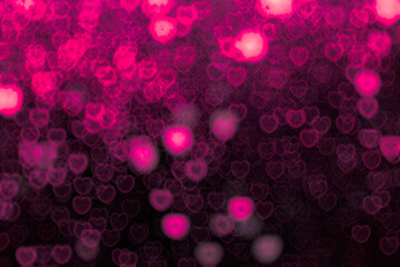 Bright and dark pink little hearts blur bokeh on black background. Design element for overlay